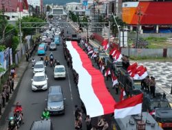 Ditsamapta Polda Sulut Bentangkan Bendera Merah Putih Berukuran 79 Meter di Boulevard Manado.